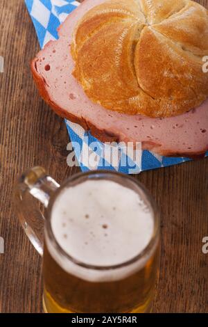 Bavarian Leberkäse in a bread roll with beer Stock Photo