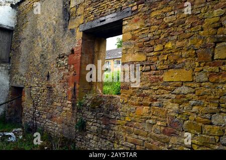 Old wall in stones with a frame of empty window and a shore. Stock Photo