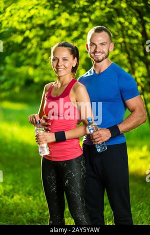 Man and woman drinking water from bottle after fitness sport exercise Stock Photo