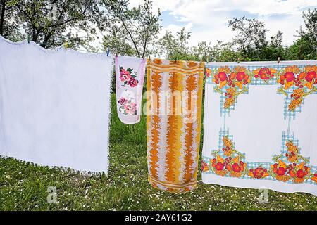In the garden on a rope dried laundered linen. Stock Photo