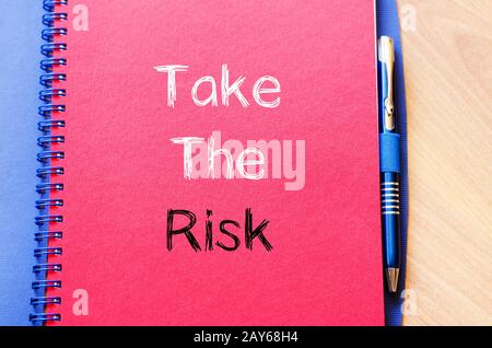 Take the risk text concept on notebook Stock Photo