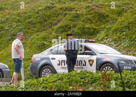 7-16-2019 Military Highway Georgia - Motorist stopped by police beside the road with background of wildflowers and lush greenery Stock Photo