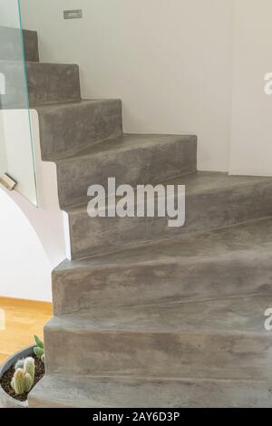 Microcement grey colour on staircase with matt finish, in combination with white walls and natural wooden floor Stock Photo