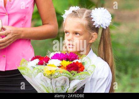 Portrait of a seven-year schoolgirl, standing next to my mother Stock Photo
