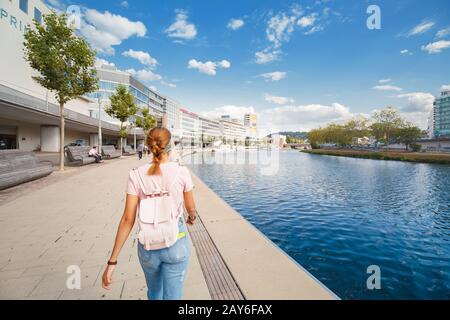 02 August 2019, Saarbrucken, Germany: Girl walking at the Saar river bank in the Saarbrucken city Stock Photo