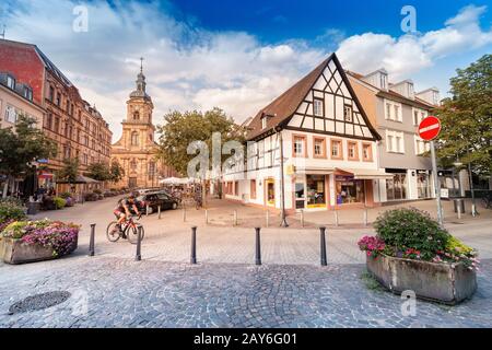 02 August 2019, Saarbrucken, Germany: View of the old town in the historic centre of Saarbrücken, with cyclists passing along the street Stock Photo