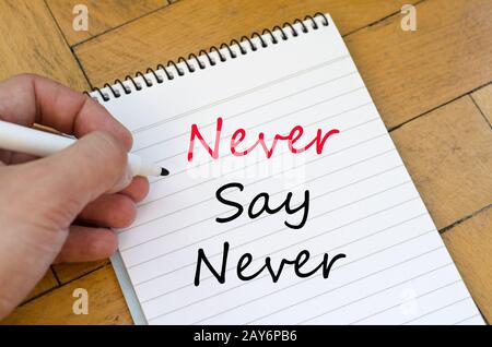 Human hand over wooden background and never say never text concept Stock Photo