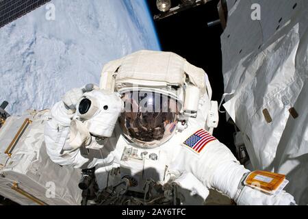A NASA astronaut spacewalks in the International Space Station. Planet Earth serves as a beautiful background. This editorial image is a NASA handout Stock Photo