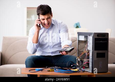 Angry customer trying to repair computer with phone support Stock Photo