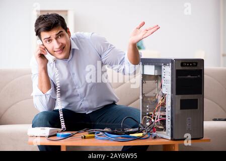 Angry customer trying to repair computer with phone support Stock Photo