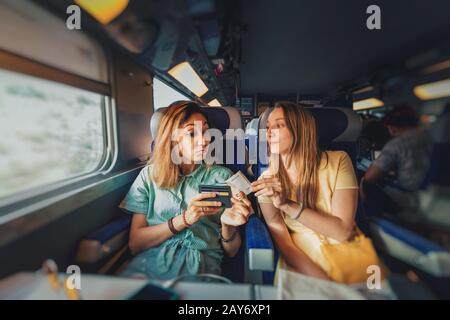 Fraud and scam girl taking money and lying to his unknown fellow traveler on the train. Stock Photo