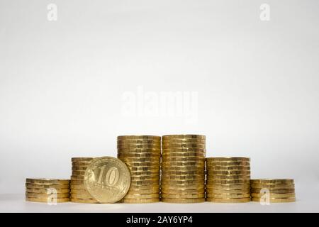 Six stacks of coins increasing height symmetrically on a white background, pockmarked stands on the edge of the Russian 10 ruble Stock Photo