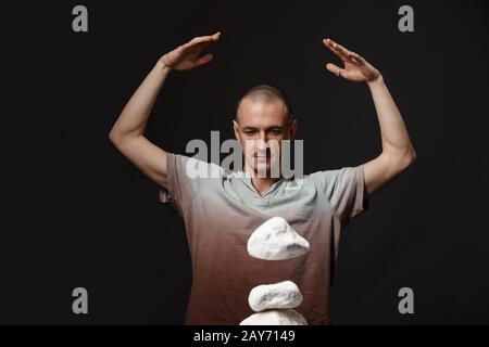 Telekinesis - man making stones levitating Stock Photo