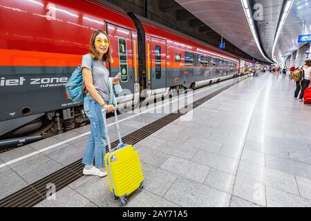 19 July 2019, Vienna airport, Austria: Traveler woman with a Suitcase Walking to the train at the underground station platform in airport Stock Photo