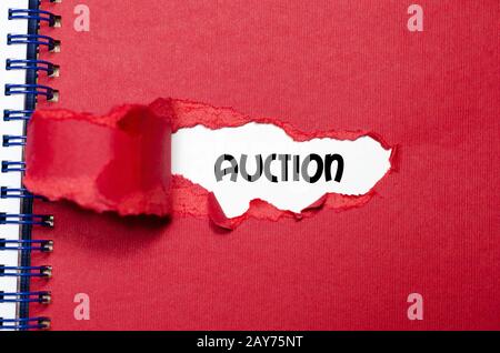 The word auction appearing behind torn paper Stock Photo