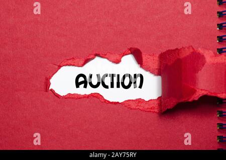 The word auction appearing behind torn paper Stock Photo