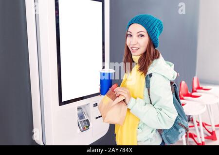 A woman orders food in the touch screen terminal with electronic menu in fast food restaurant Stock Photo