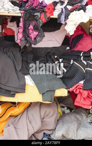 Pile of carelessly scattered clothes in wardrobe Stock Photo