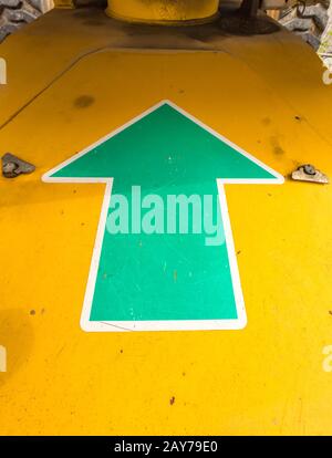 Green arrow on a machine pointing upwards Stock Photo