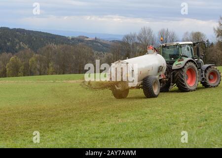 Farmer fertilizes meadow with liquid manure - close-up of liquid manure barrel in action Stock Photo