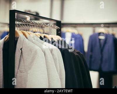Hangers with different male clothes in store Stock Photo