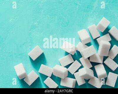 Top view of white sugar cubes on blue concrete background Stock Photo