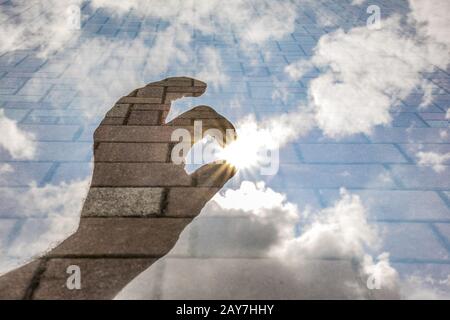 Hand reaching for the sun with paving stones as a background Stock Photo