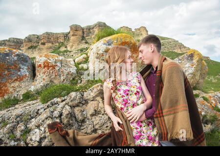 Young couple in love embraces gently against the blue sky and white clouds Stock Photo