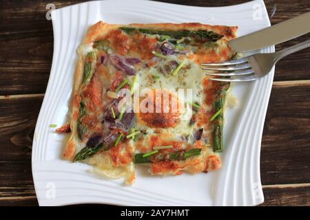 A delicious and tasty snack. Puff pastry with salmon, egg and asparagus . Stuffed puff pastry, quick snack. Delicious breakfast. Stock Photo