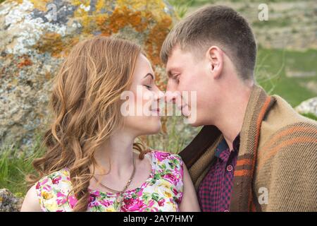 Young couple in love embraces gently against the blue sky and white clouds Stock Photo