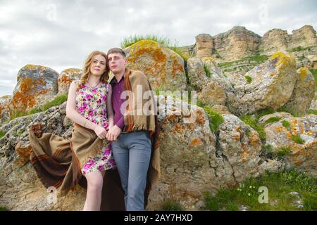 portrait of a guy with a girl covered in a blanket standing in an embrace in nature and smiling with happiness Stock Photo