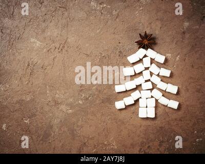 Christmas tree made from marshmallow and star anise on brown concrete background Stock Photo