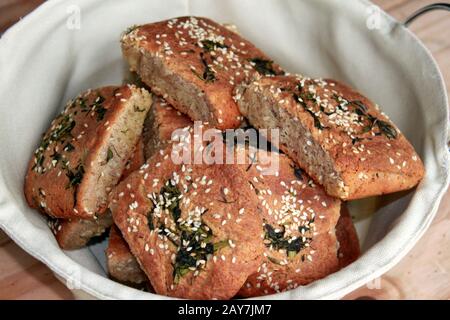 Homemade sesame buns. Rolls in a small basket. Whole wheat bread. Stock Photo