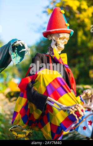 a skeleton is biking while the bone of a hand follows it Stock Photo