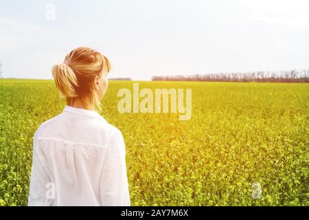 The beauty of a girl outdoors, enjoying nature and freedom and enjoying life. Beautiful girl in a white shirt, strolls on a spri Stock Photo