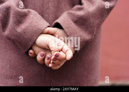 Portrait of a woman hands in a burgundy coat view from the back Stock Photo
