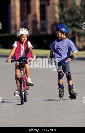 Austin, Texas: Kids rollerblading and bike riding in middle-class neighborhood.  MR  ©Bob Daemmrich/ Stock Photo