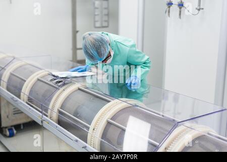 scientist is making notes about a machine Stock Photo