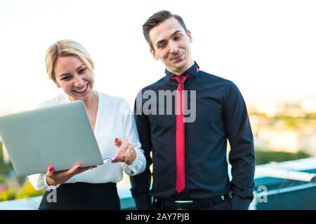 Couple of businessmen, serious brunette man and attractive blond Stock Photo