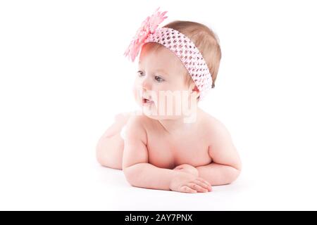beautiful cute baby girl in pink flower wrap lies on tummy Stock Photo