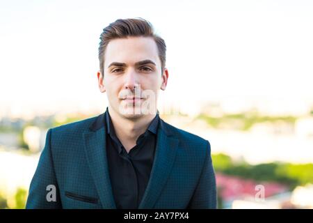 Attractive serious busunessman in dark suit and black shirt Stock Photo