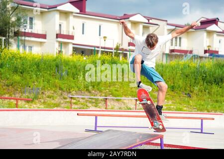 A boy in a skate park doing a trick on a skateboard Stock Photo