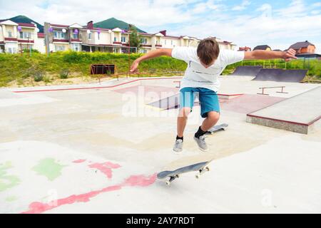 A boy in a skate park doing a trick on a skateboard Stock Photo