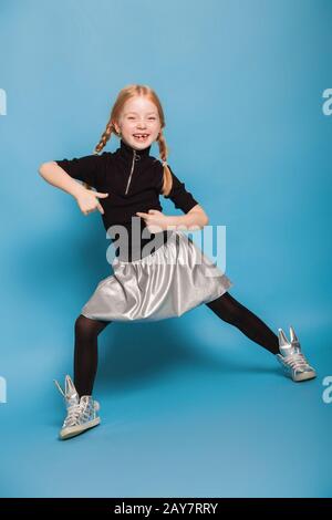 little girl with braids in stylish clothes on blue background Stock Photo