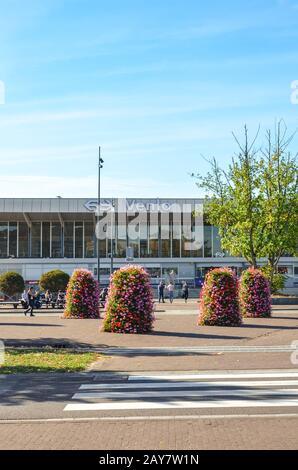 Venlo, Limburg, Netherlands - October 13, 2018: Zebra crossing and sidewalk leading to the main train station building in the Dutch city. Flower decorations, people on the street.