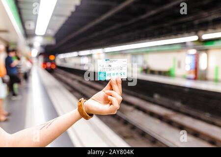 10 JULY 2018, BARCELONA, SPAIN: Woman traveler holds Barcelona public transport T-10 ticket in subway Stock Photo