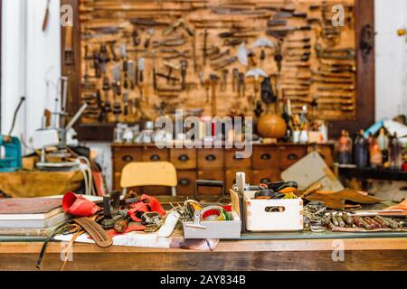 Various old vintage tools on the board in leather craft workshop, manual work concept Stock Photo