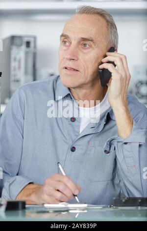 senior businessman talking on a mobile phone in office Stock Photo