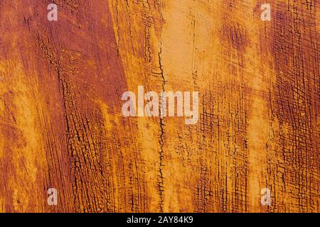 Textured background of a faded yellow paint with rusted cracks on rusted metal. Grunge texture of an old cracked metal surface. Stock Photo