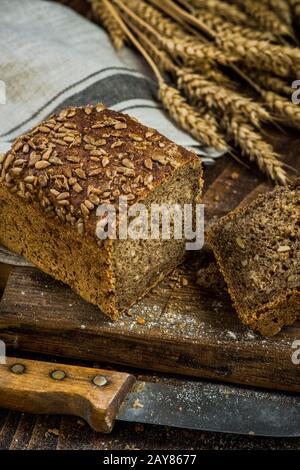 Wholegrain bread with seeds sliced on board Stock Photo - Alamy